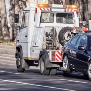 A tow truck towing a car in British Columbia, during a vehicle repossession process