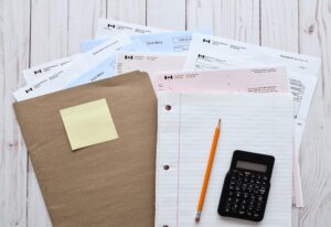 Tax documents and a calculator are arranged on a desk for financial review in British Columbia.