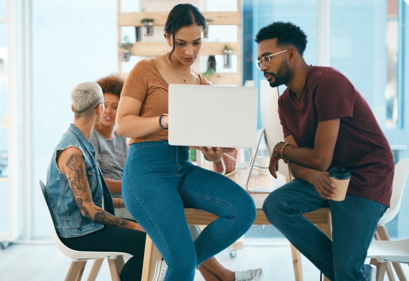 Team working together on a laptop discussing a small business solution in British Columbia