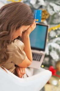 A woman in British Columbia is holding a credit card while using a laptop for online payment